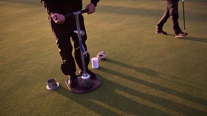 A greenkeeper switches hole locations at the 152nd Open Championship at Royal Troon