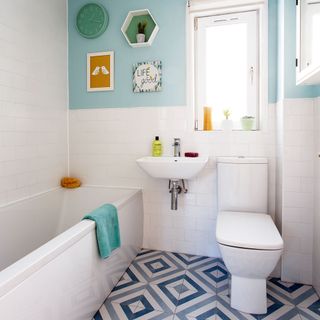 bathroom with multicolour walls and tiles flooring and bathtub and commode