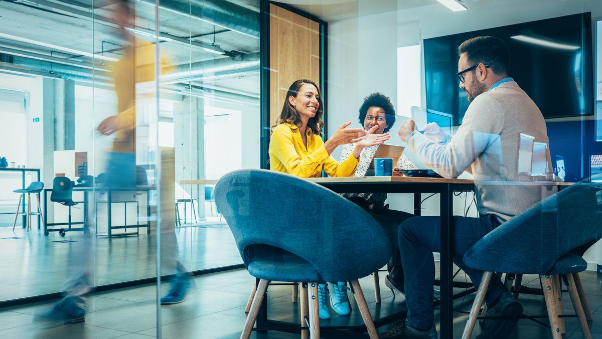 Three employees in a meeting space.