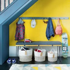 yellow wall with coat rack under staircase
