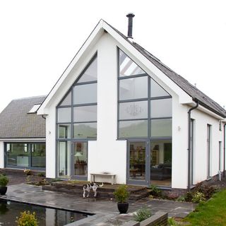 sloping roof house with white walls and grey glass door