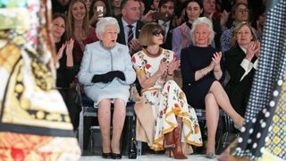 Queen Elizabeth II sitting with Anna Wintour and her long-term dresser, Angela Kelly