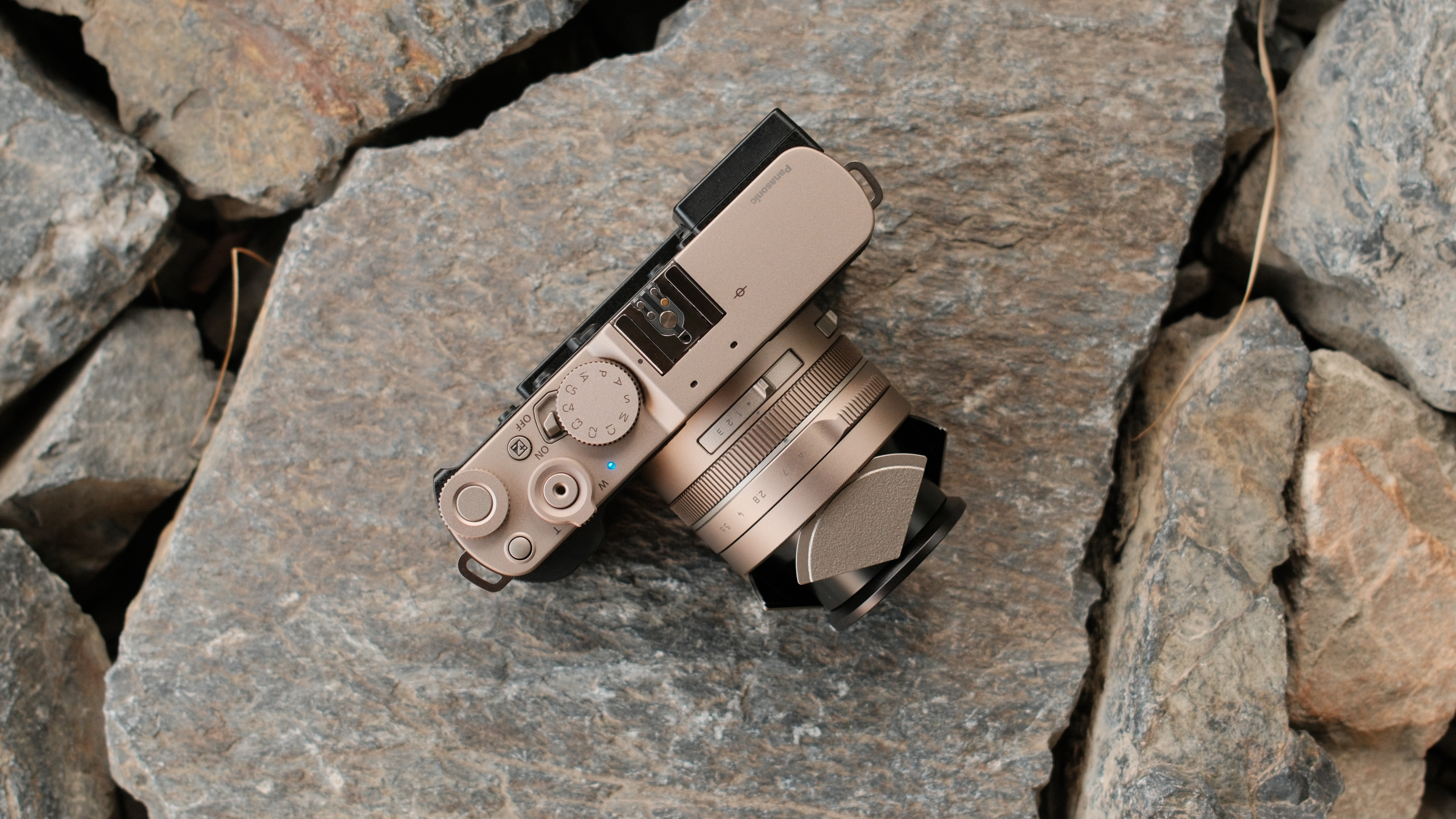 Panasonic Lumix L10 camera lying on rocks with its lens extended.