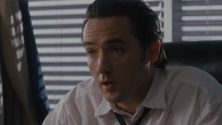 Marshal Vince Larkin sitting behind desk in office in Con Air
