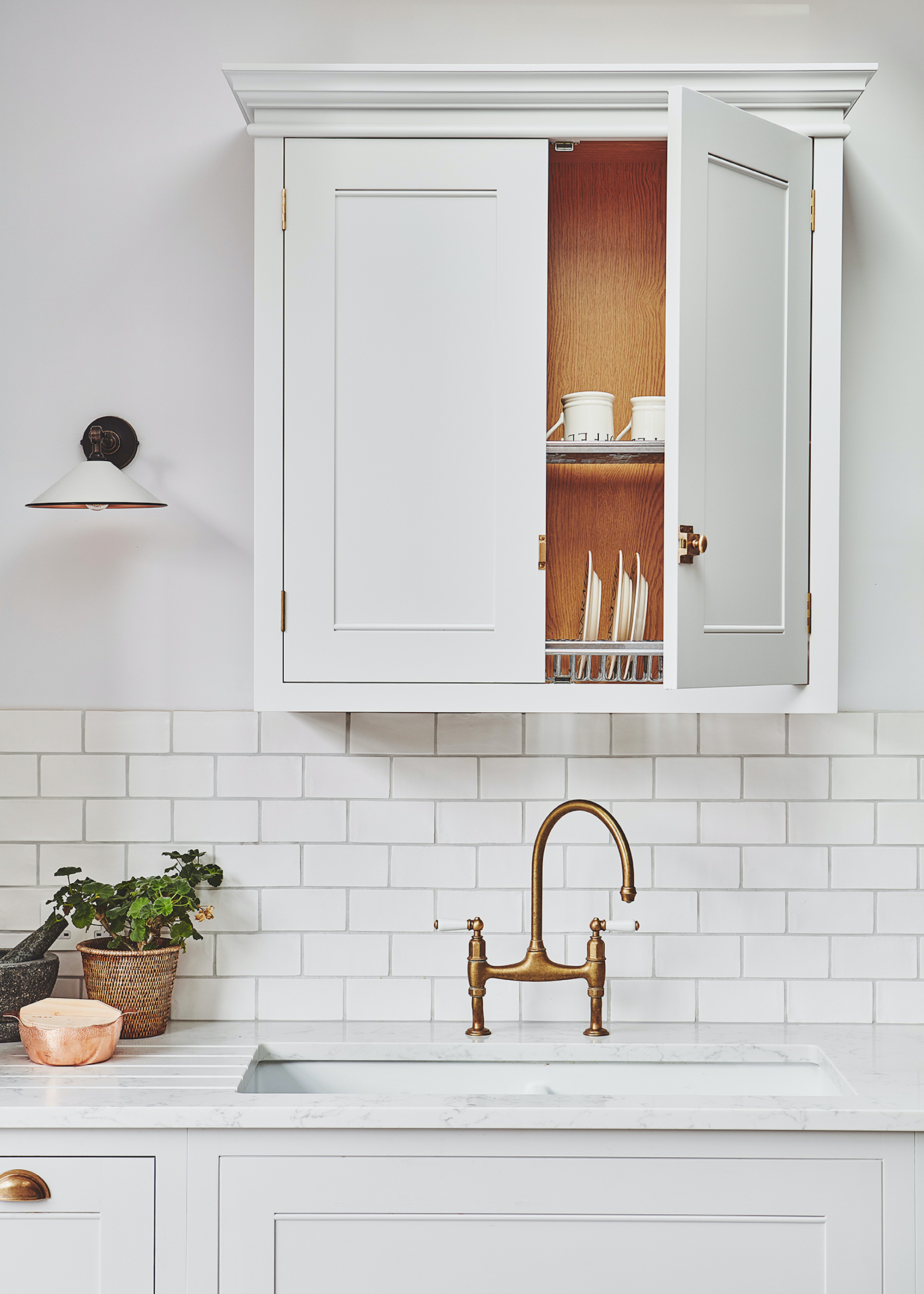 kitchen with open cupboard above sink with plates and mugs inside of the cupboard