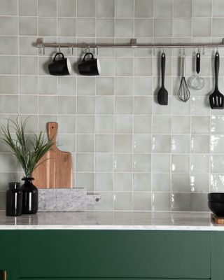 light blue grey tiles on splashback of green kitchen