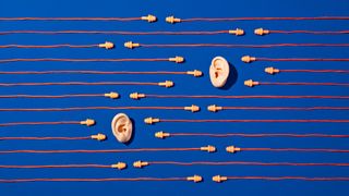 Two ears and multiple sets of earplugs on a blue background