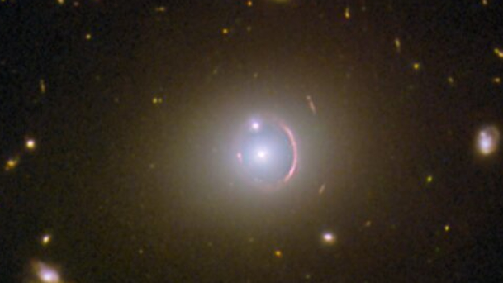 A ring of light with a bright galaxy at its center and another galaxy aligned with the ring like an engagement ring
