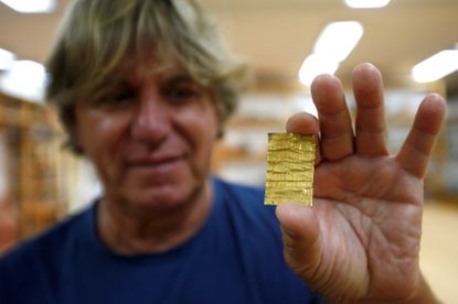 Miomir Korac displays recently found golden amulet at the Viminacium site.