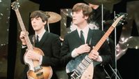 Paul McCartney (left) and John Lennon (1940 - 1980) perform on the set of 'The Ed Sullivan Show' at CBS's Studio 50, New York, New York, February 8, 1964 