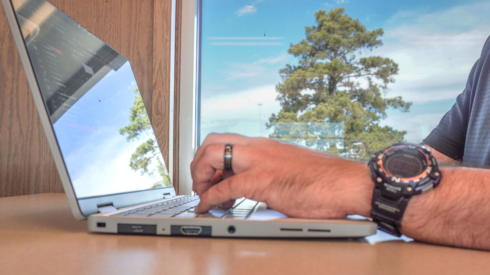 A person typing on the Framework Laptop 12 with a lot of glare from outside on the screen