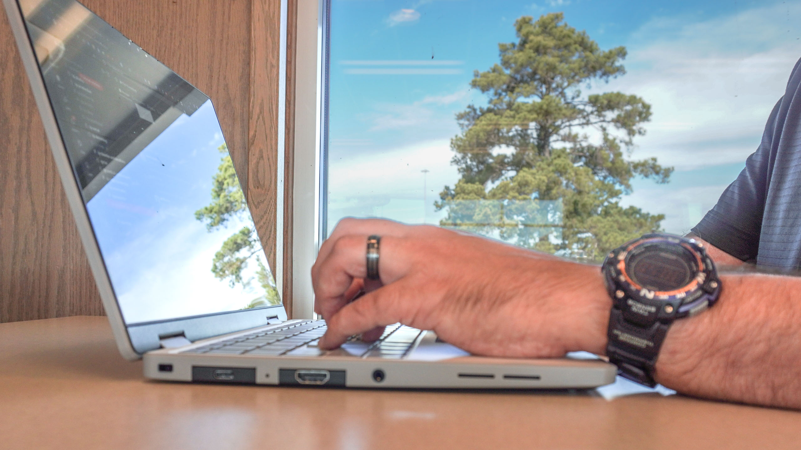 A person typing on the Framework Laptop 12 with a lot of glare from outside on the screen