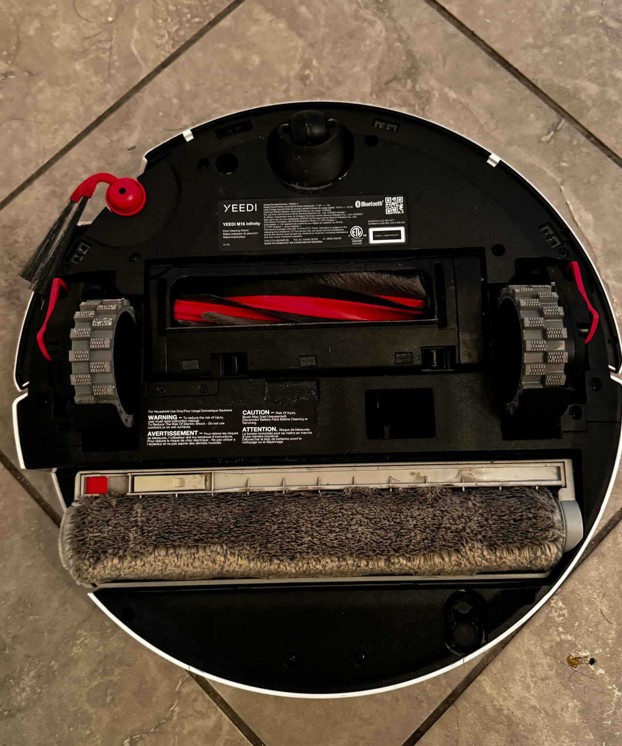 Bottom of the Yeedi M16 Infinity showing the roller mop, wheels, and brushes.