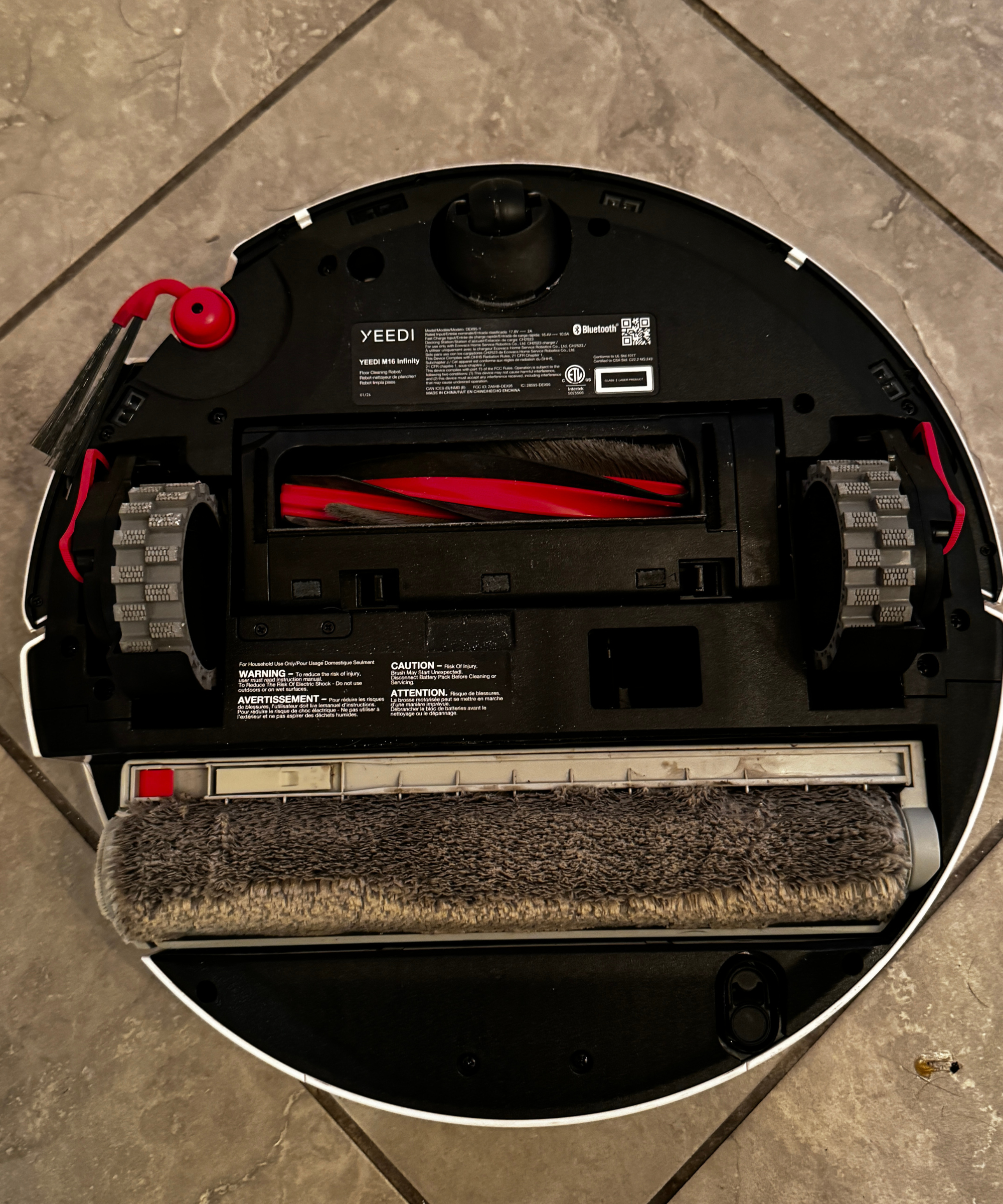 Bottom of the Yeedi M16 Infinity showing the wide roller mop wheels, and brushes.