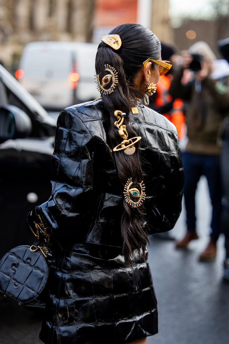Sabrina Harrison wears golden hair clips, black bag, vinyl jacket with golden details