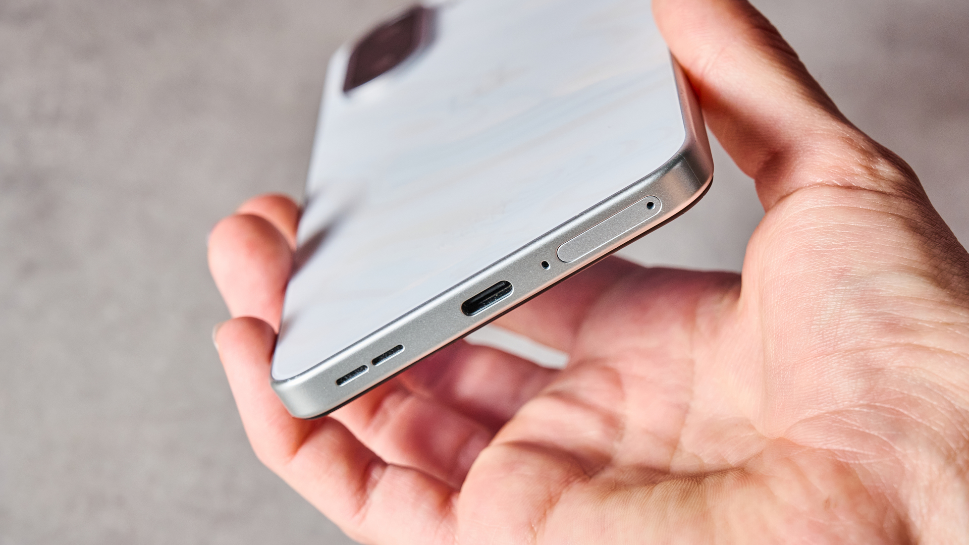 A woman's hand showing the USB-C port of the OnePlus Nord CE5.