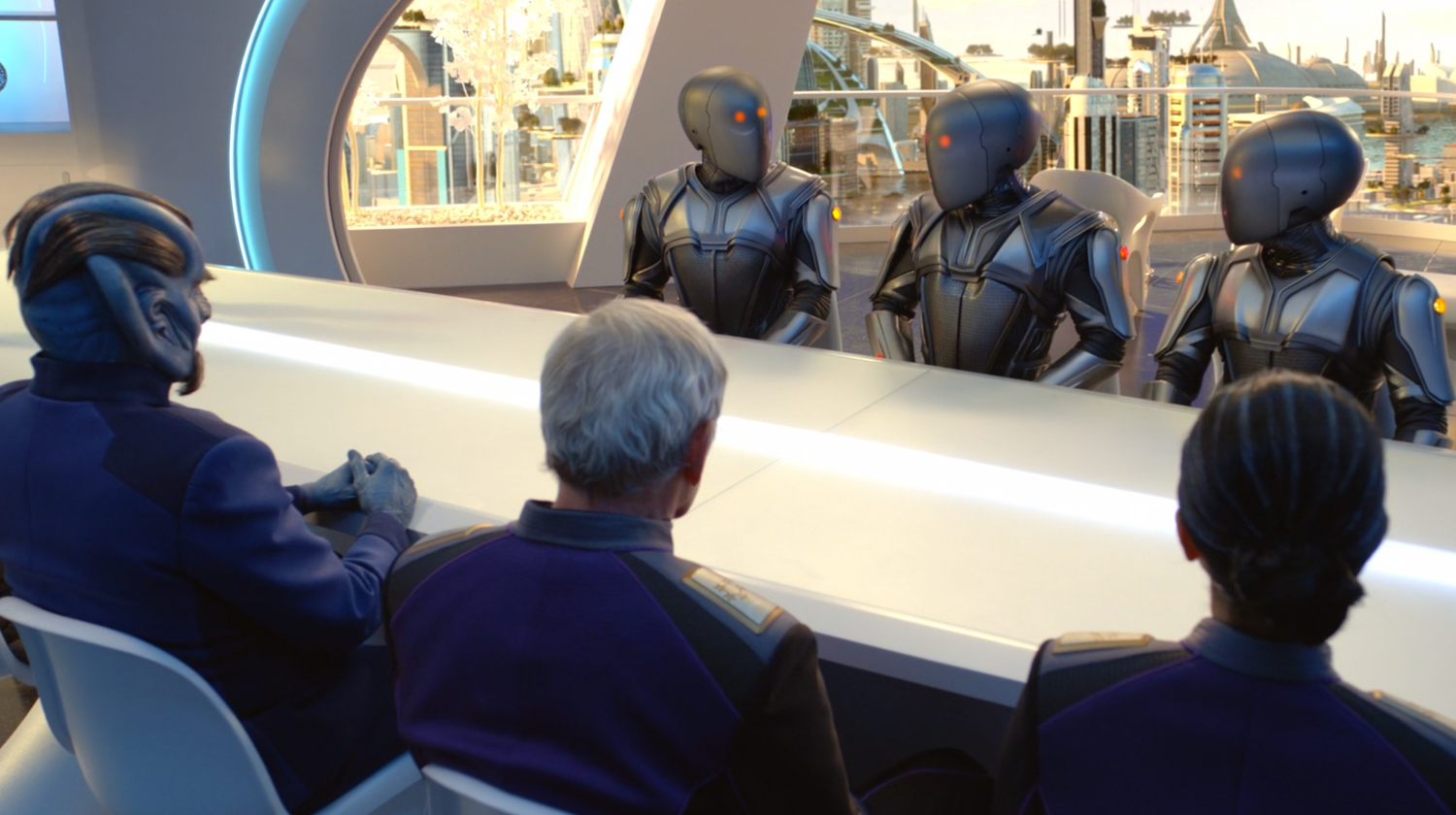 Members of different alien species sit down for a discussion at a large, white table. A futuristic cityscape can be seen out a large window behind them.