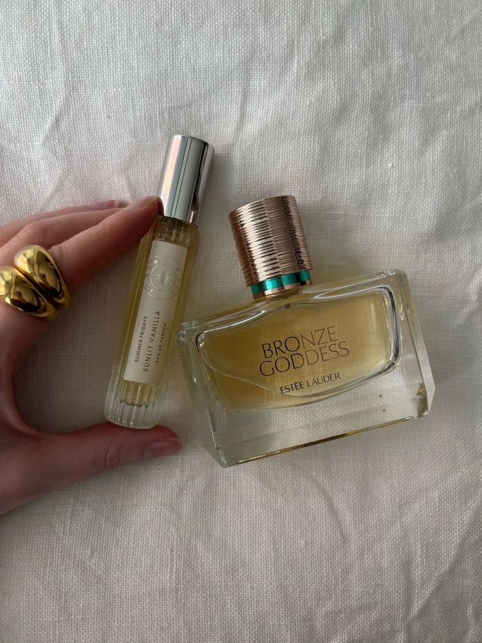 Deputy beauty editor Grace Lindsay holding two of the best vanilla and coconut perfumes
