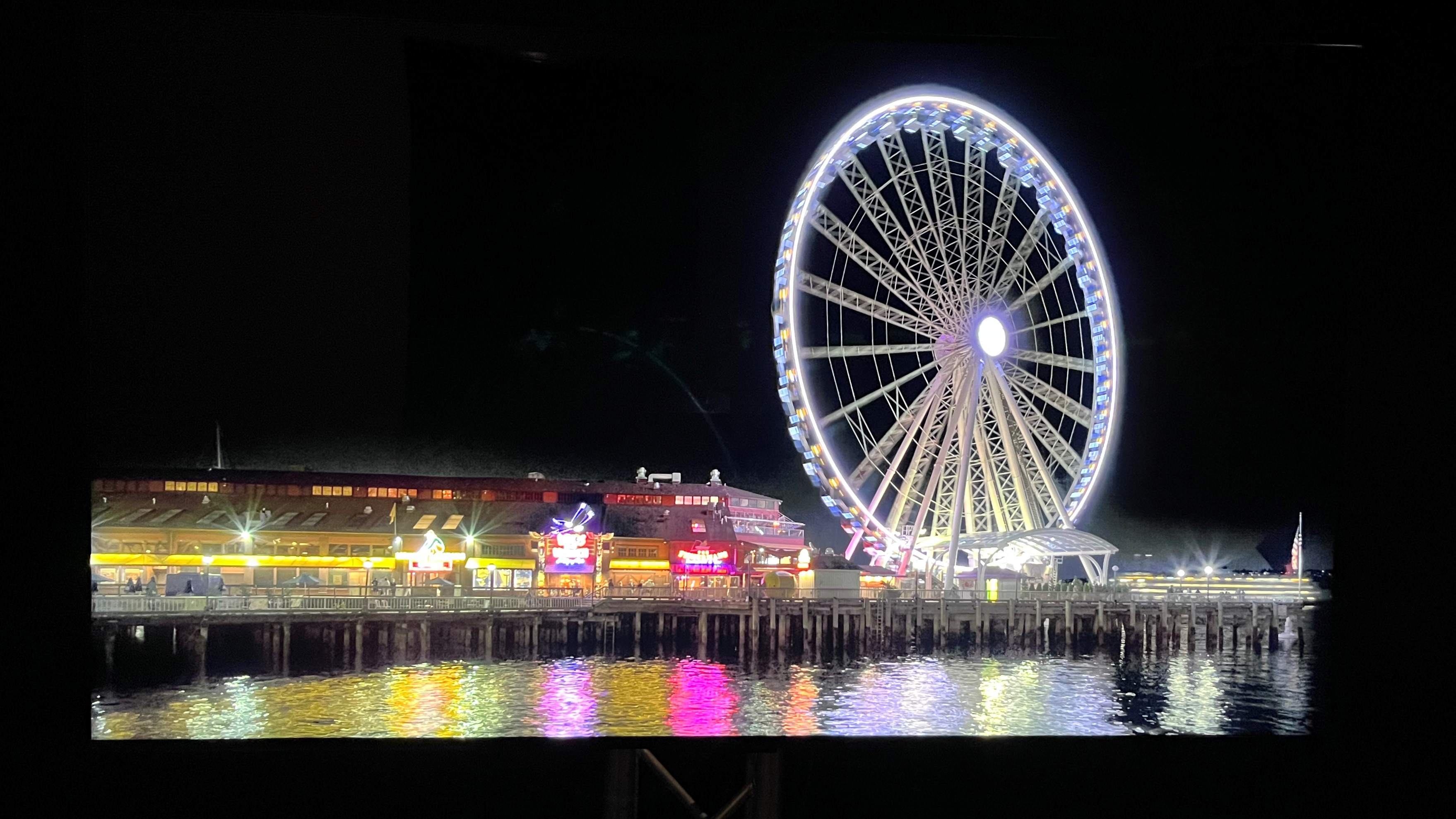 TCL QM8 TV showing Ferris wheel at night onscreen