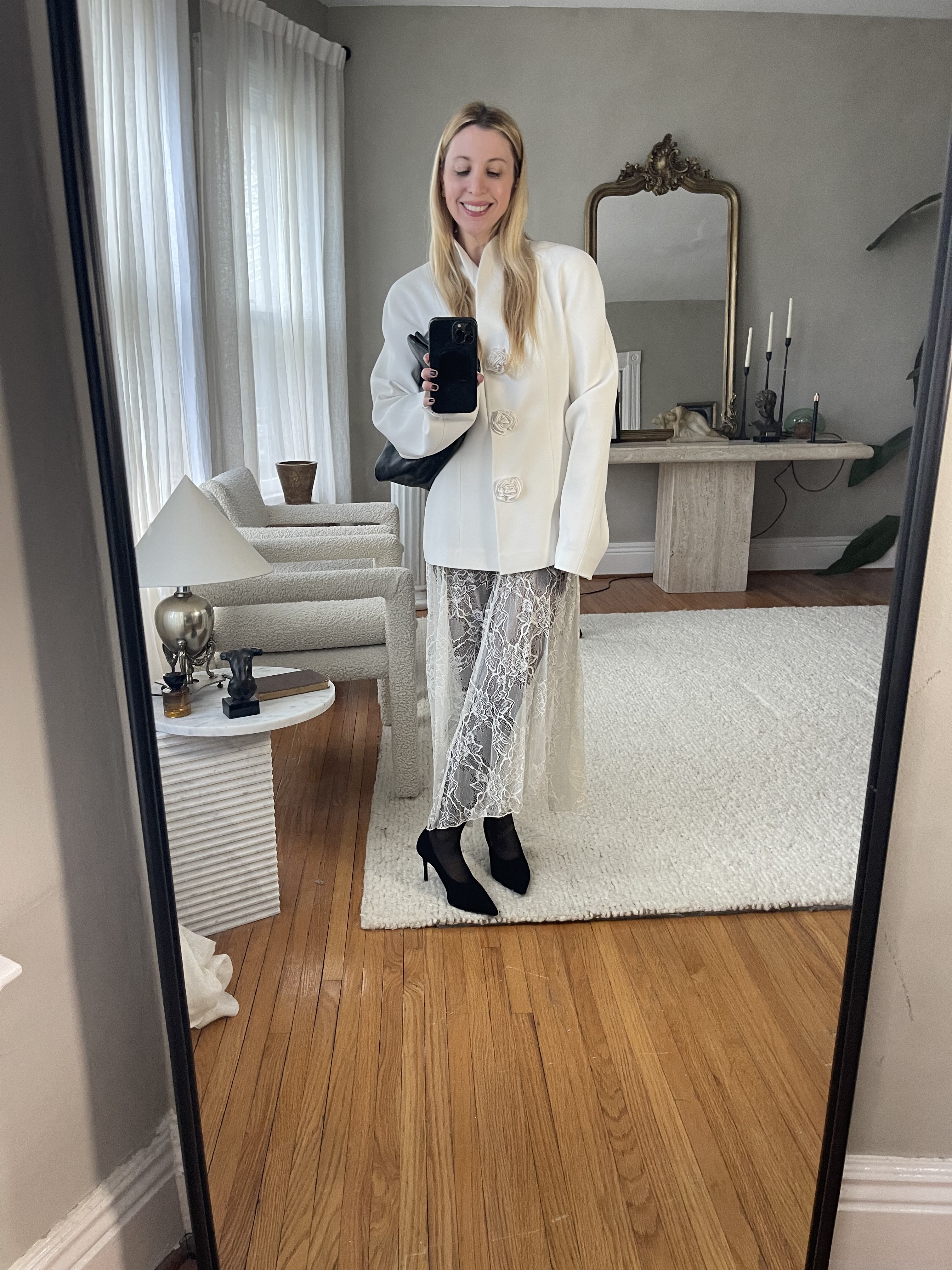 Kerry Pieri in a white blazer and white lace skirt