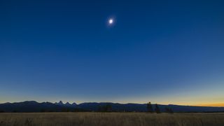  Total solar eclipse over the Grand Tetons as seen from the Teton Valley in Idaho, near Driggs. This is from a 700-frame time-lapse and is of third contact just as the second diamond ring is starting and the dark shadow of the Moon is receding to the east at left. The sky is darker to the left but the foregound is beginning to light up as the sky to the west off camera to the right brightens and lights the scene. Jupiter is just above the Tetons at bottom.