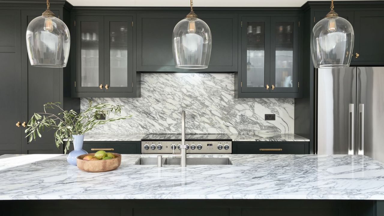 Painted Shaker Kitchen with stunning Arabescato worktop. Painted in Little Greene Obsidian Green. Corston Kilburn Furniture knobs and handles in Antique Brass finish. Rangemaster cooker with induction top.