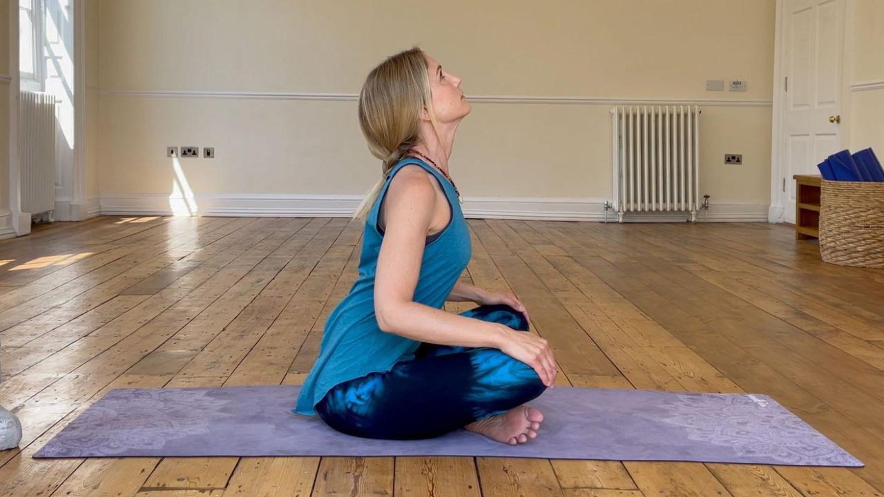 Michelle Maslin-Taylor, yoga teacher, demonstrates seated cat pose