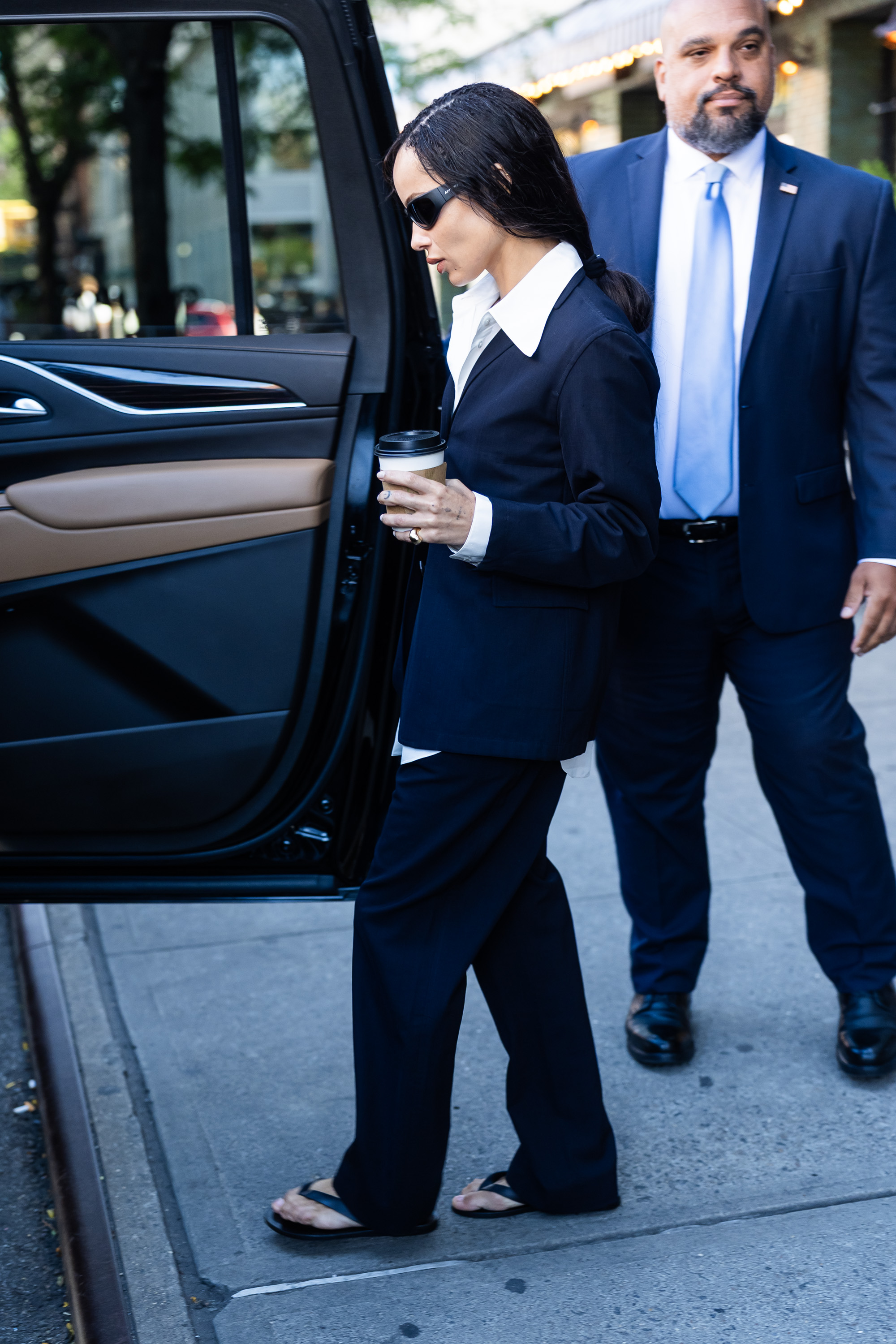 An image of Zo&amp;euml; Kravitz wearing an oversized blazer, pleated trousers and flip-flops as part of her autumn capsule wardrobe.