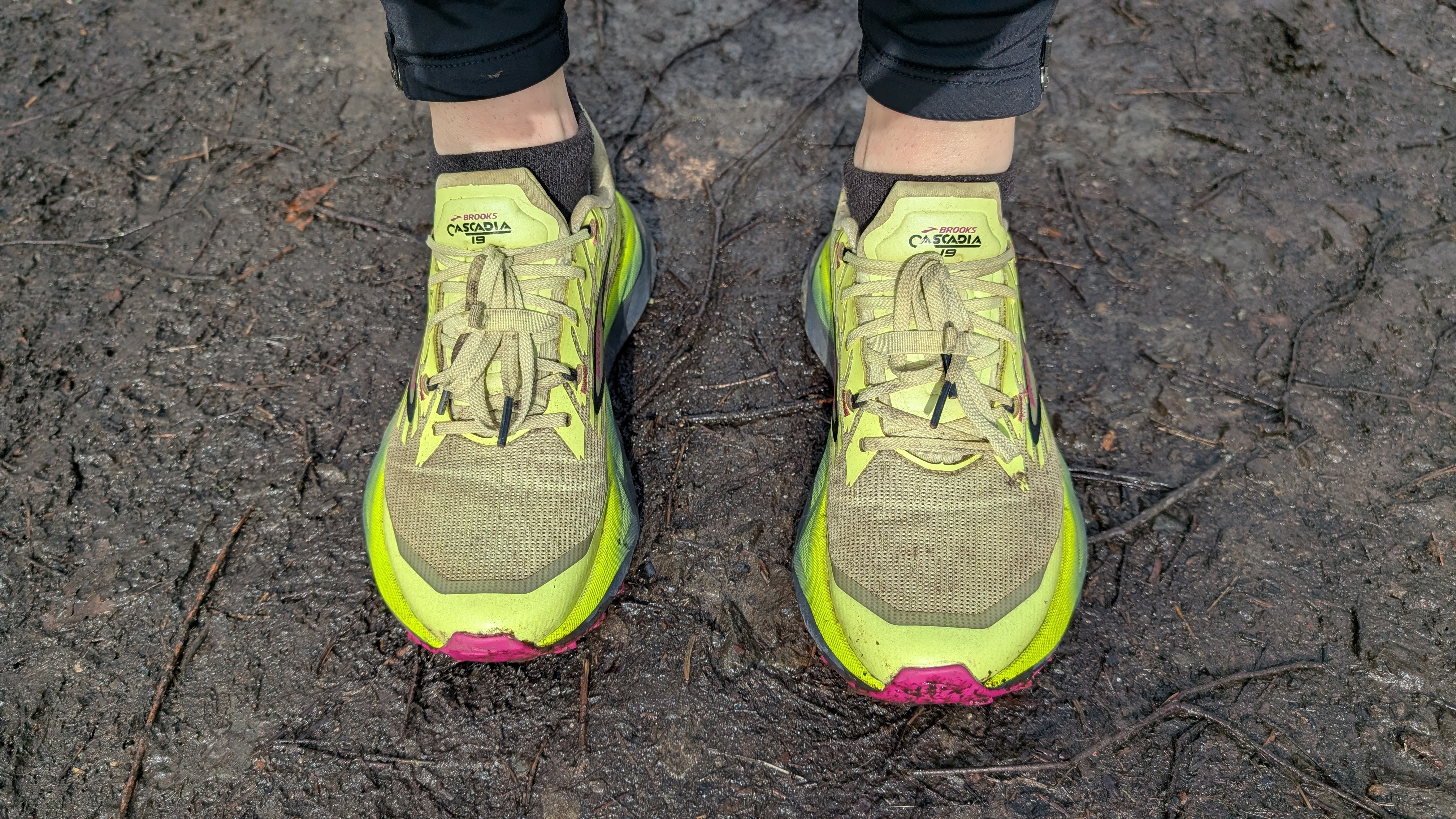 A runner's feet wearing the Brooks Cascadia 19 shoes in yellow