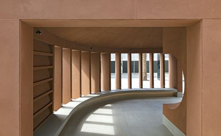 A light brown detail of a building, with flat columns that let in light.