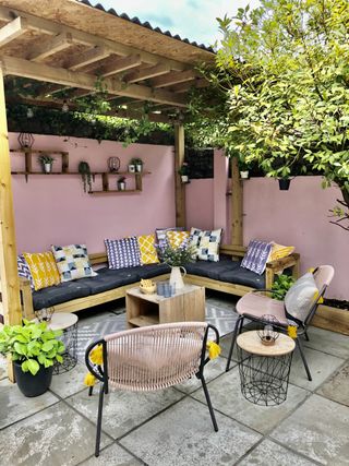 DIY pergola and corner sofa with pink painted garden walls