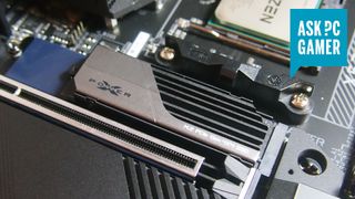 A photo of a Silicon Power SSD mounted in an M.2 slot on an AMD motherboard, with an 'Ask PC Gamer' logo in the top right hand corner