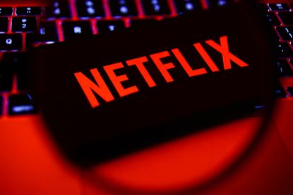 Netflix logo on smartphone sitting on computer keyboard