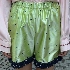 Model wearing green polka dot caro editions shorts.