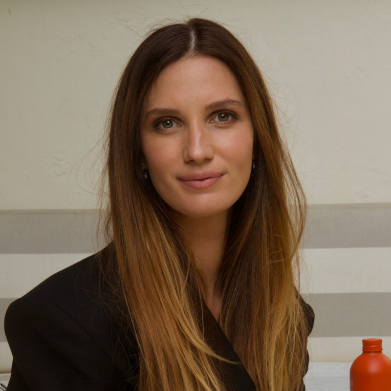 a woman with light brown hair in a black jacket