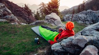 Man sitting in bivy sack on a mountain