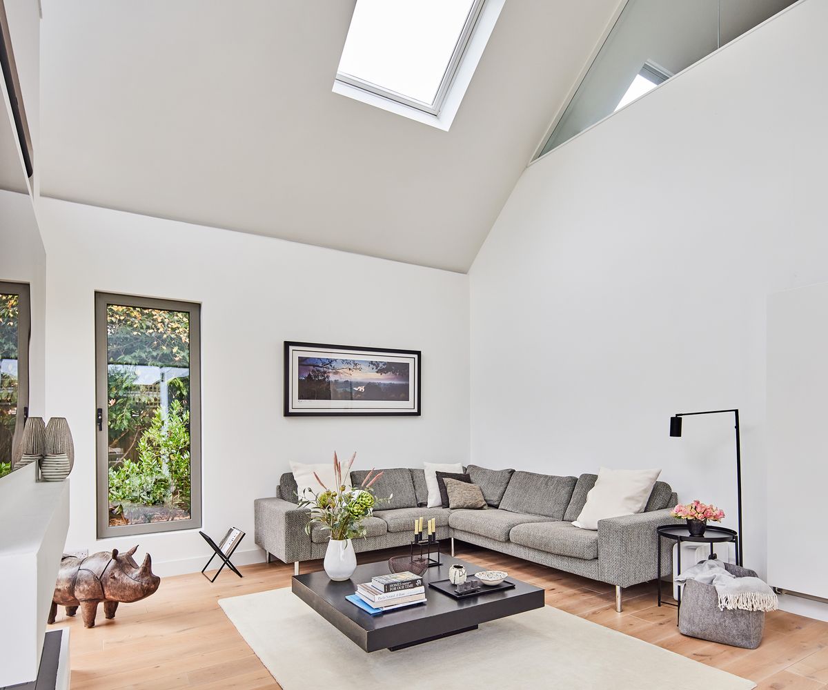 A living room with high pitched ceilings and skylights bringing plenty of natural light