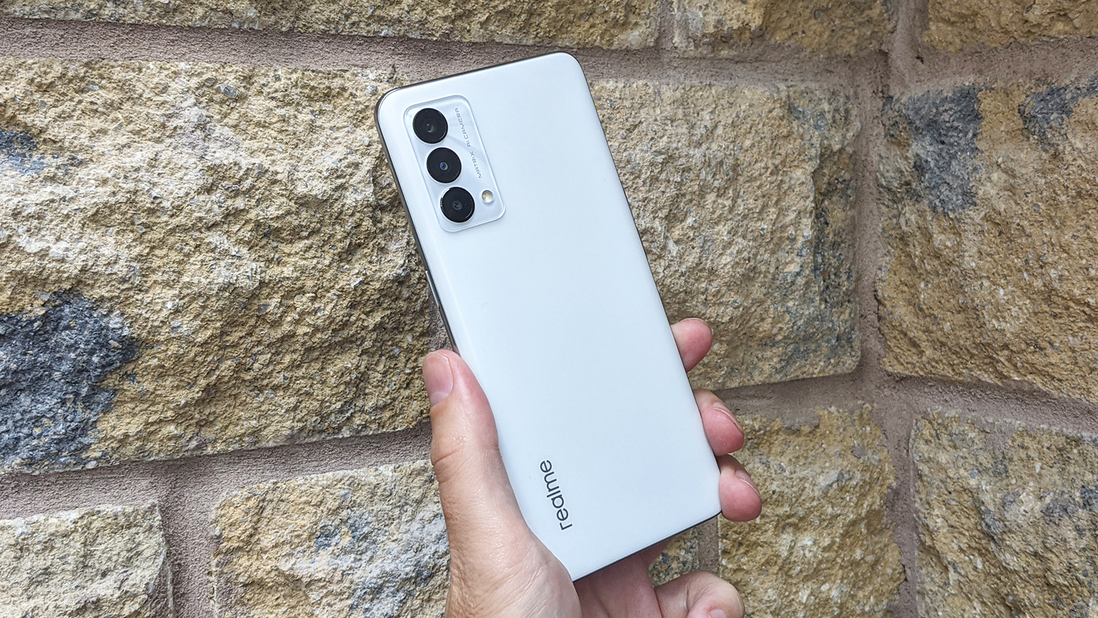 The back of the Realme GT Master Edition against a wall.