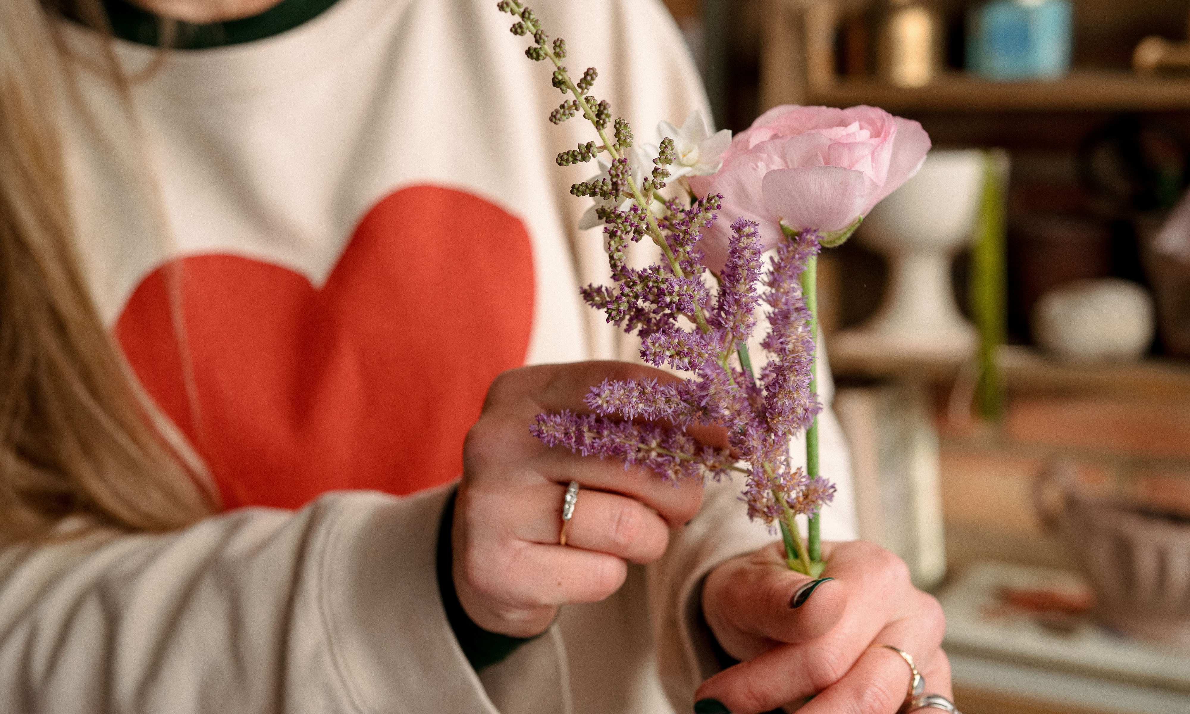 hand holding a ranunculus and an astilbe stem