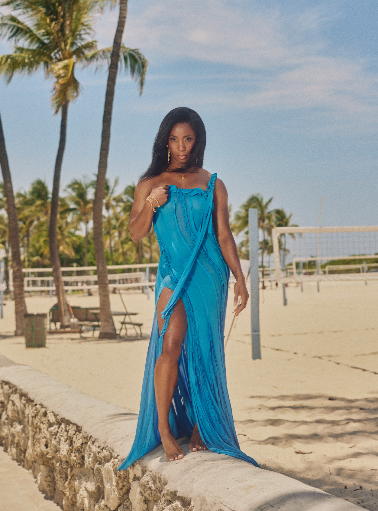 Shelly Ann Fraser Pryce wearing a blue dress on a beach backdrop