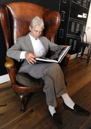 Charlie Watts reading a copy of Rolling Stones: 50