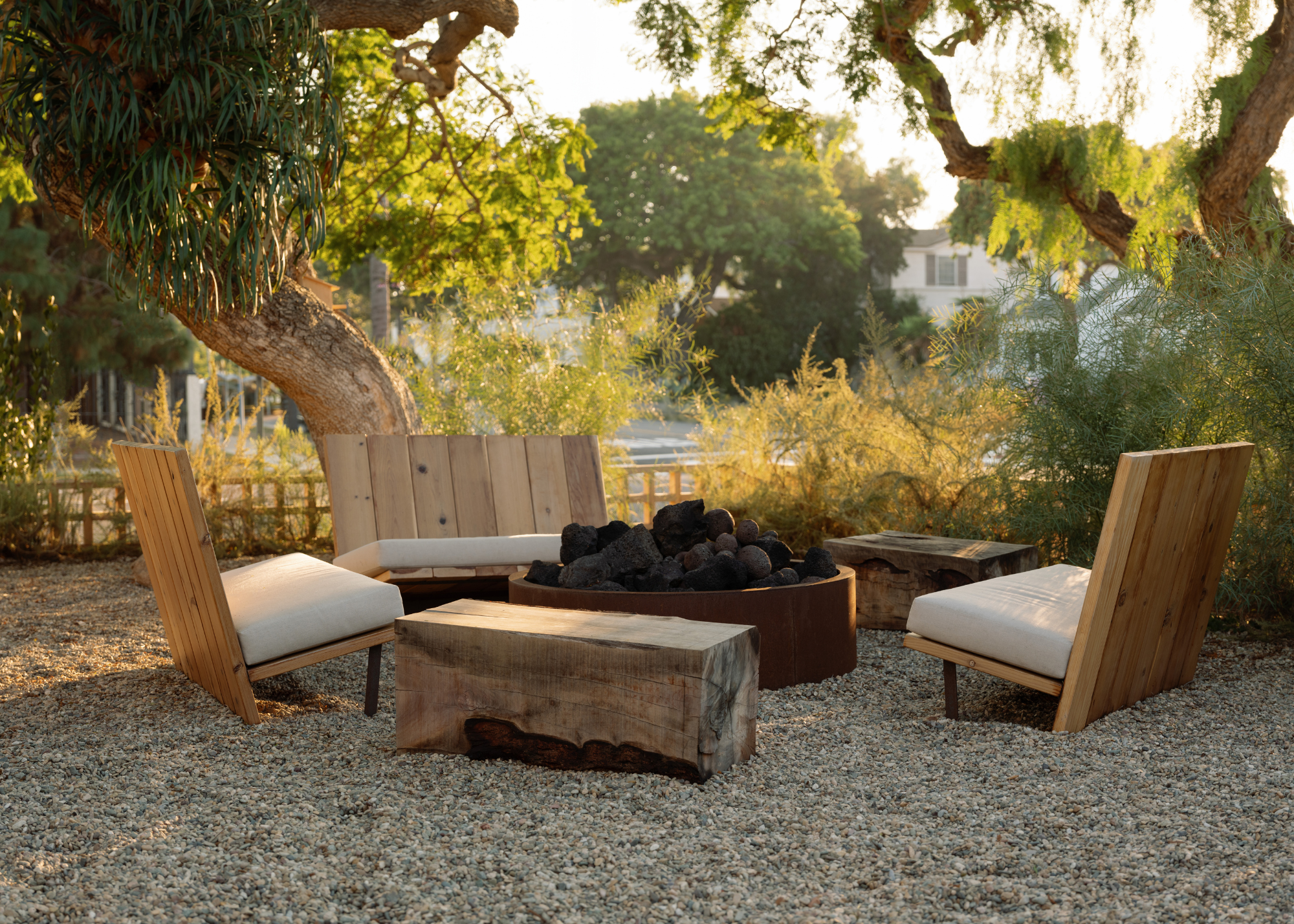 an outdoor seating area around a fireplace in a pebbled garden