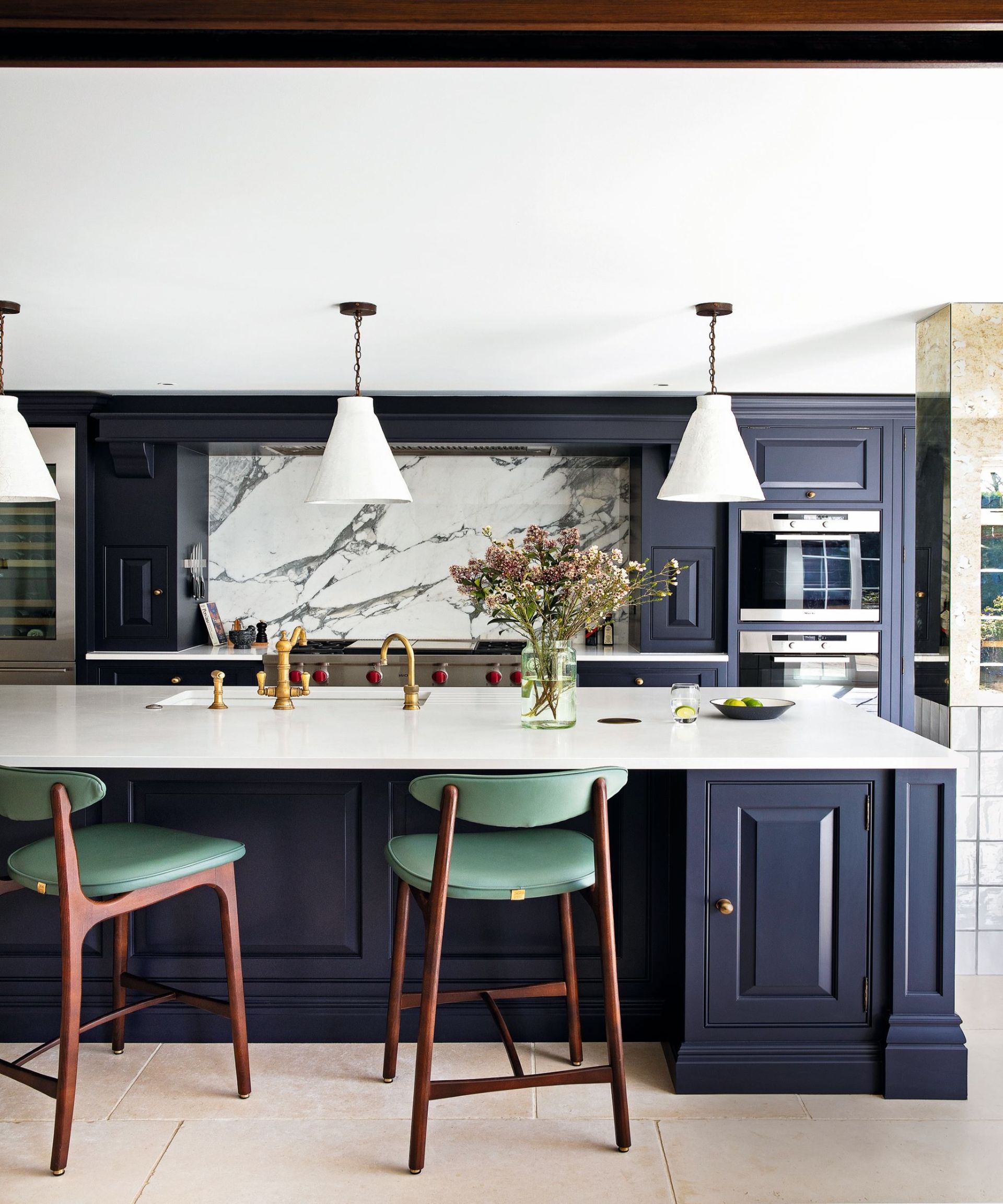 kitchen with purple cupboards, marble worktops and green bar stools