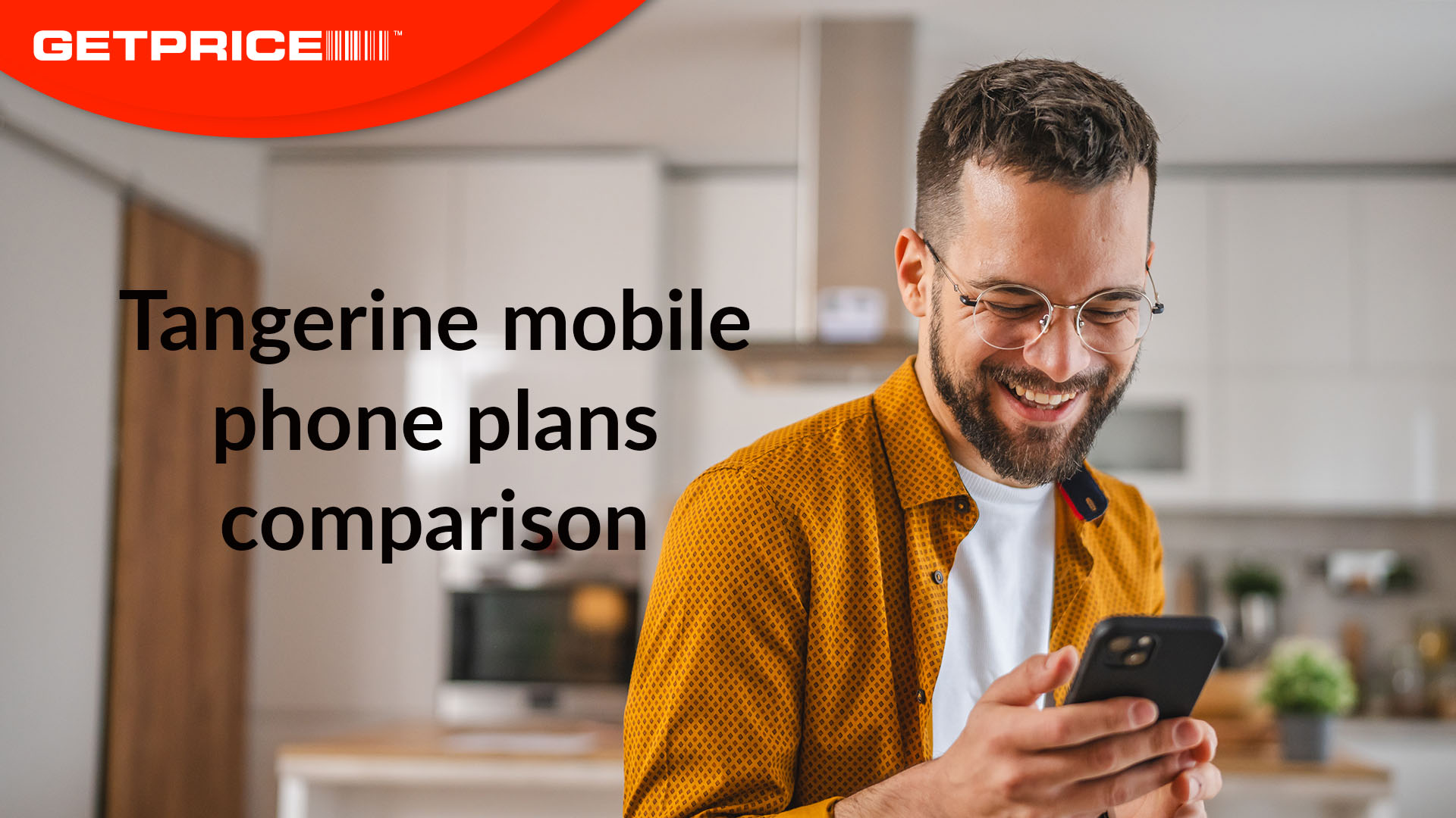 Man standing in kitchen smiling down at mobile phone with red GetPrice logo on top left corner with black writing underneath that says &#039;Tangerine mobile phone plans comparison&#039;
