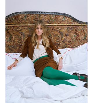 Mackenzie Davis at Hotel Chelsea wearing a brown suede Miu Miu jacket and matching skirt with green tights.