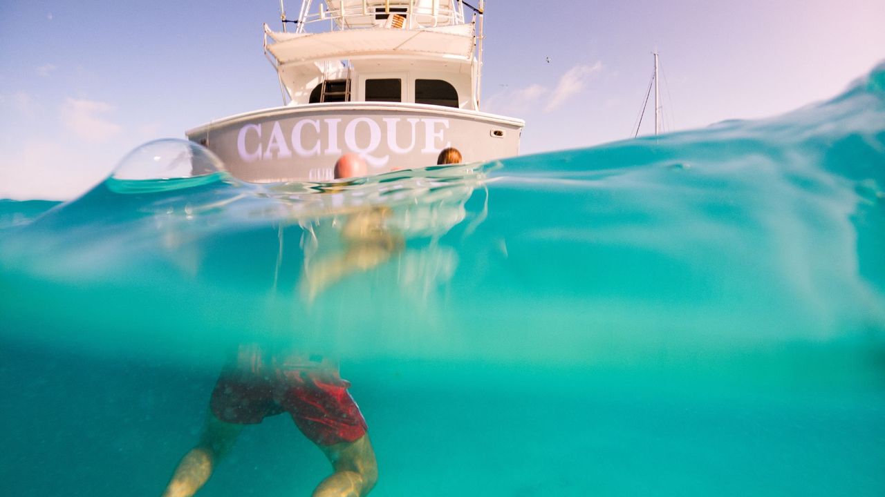 A couple swimming in the pristine waters surrounding Sandals Curacao