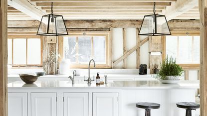 White kitchen island with metal tap in wooden kitchen