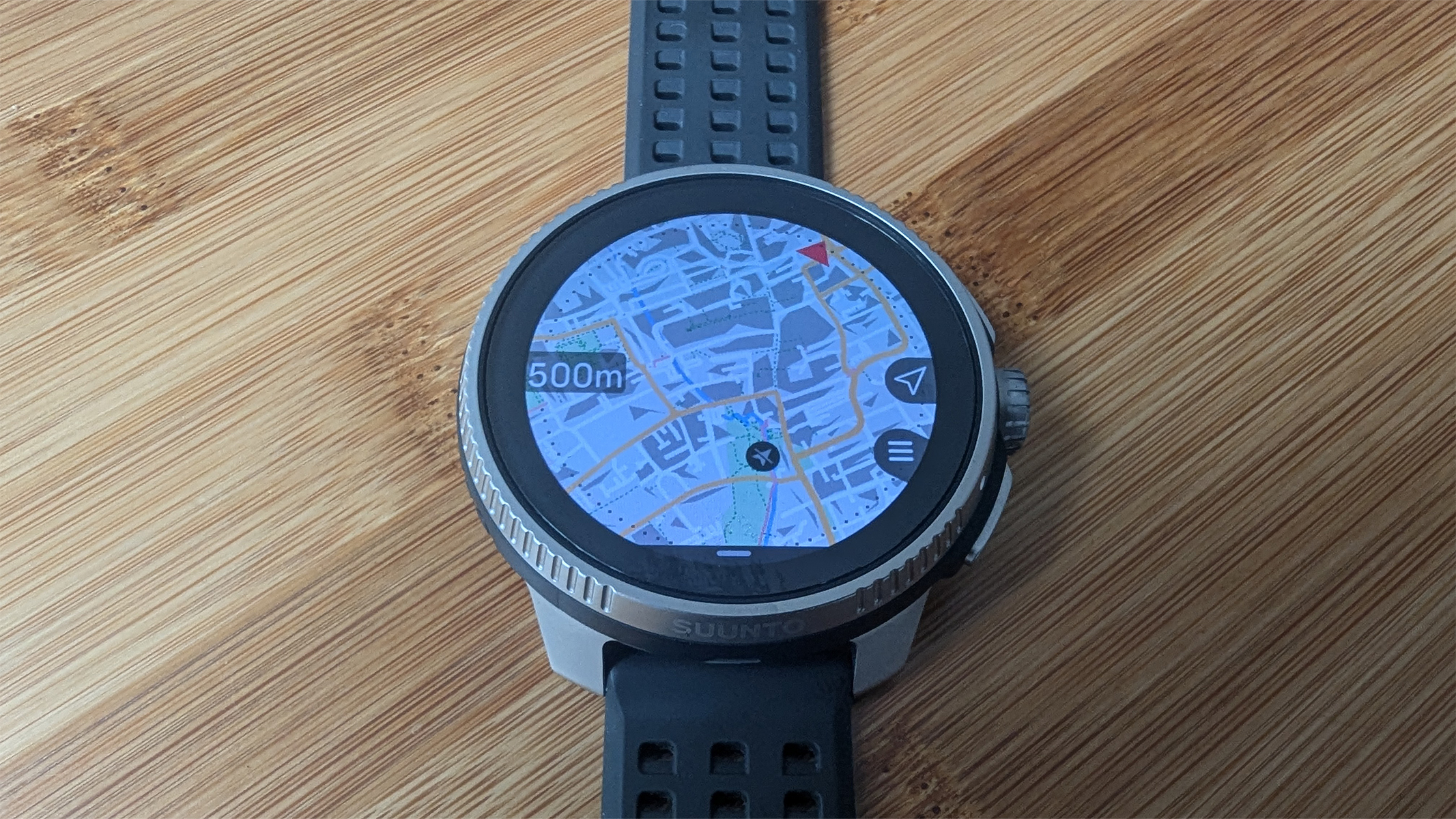 Suunto Race on a bamboo table showing an on screen map.