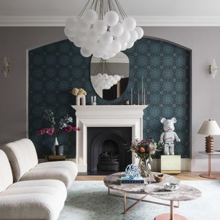 Living room with blue wallpapered chimney breast.