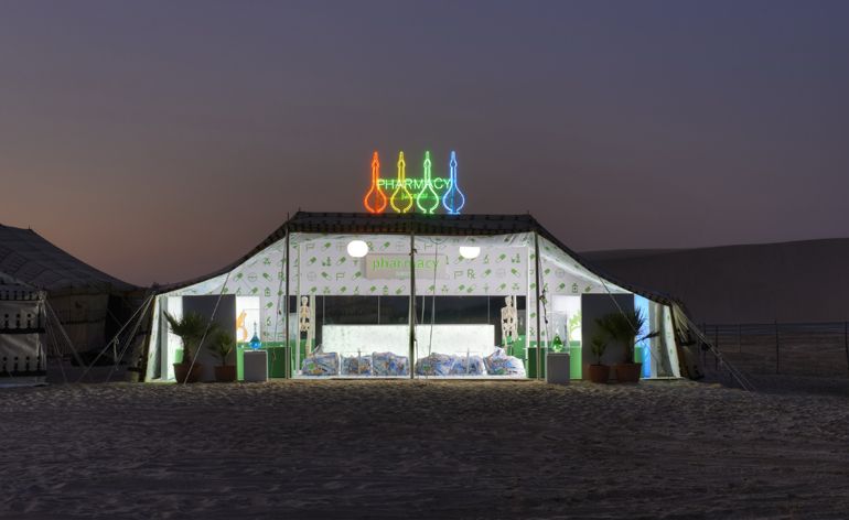 A Bedouin tent in the desert, at night. The tent is set out as the Pharmacy Juice Bar.